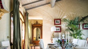 A dining area with a table set for a meal, a mirror, and framed pictures on the wall.
