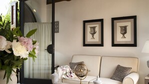 A room with a white sofa, a coffee table with decorative items, a globe, and framed pictures on the wall.