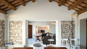 A spacious living area with stone walls, a fireplace, and a television.