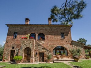A stone building with arched windows, a central door, and a small tower.
