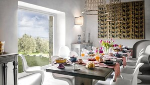 Een eethoek met een ontbijttafel, uitzicht op de omgeving en een decoratief wandobject.