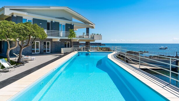 Ein modernes Resort mit Schwimmbad, Balkon und Meerblick.