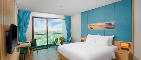 Une chambre d’hôtel avec un grand lit, un bureau avec une chaise, une télévision et une vue sur la ville.