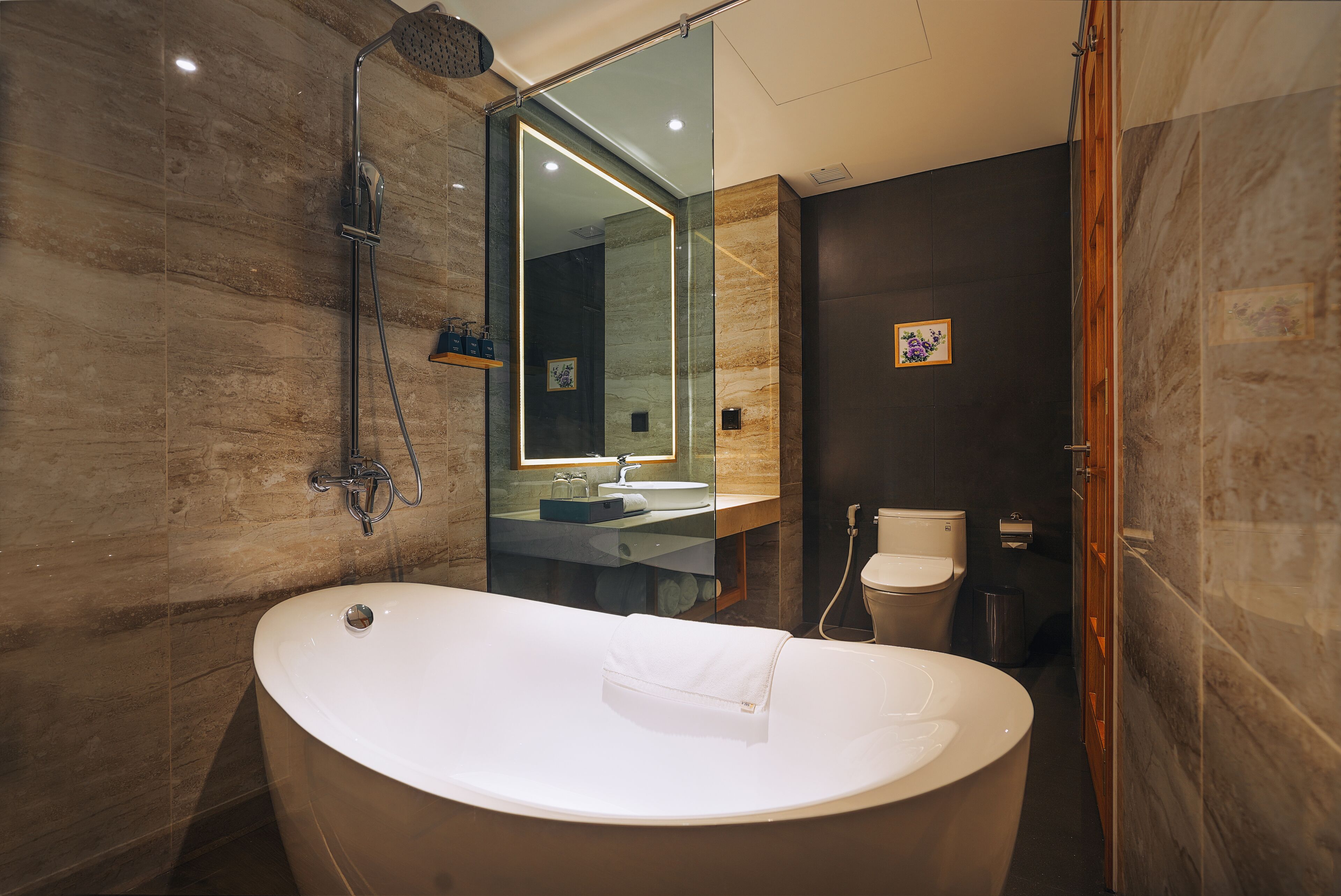 A modern bathroom with a freestanding bathtub, a glass-enclosed shower, and a vanity with a mirror.