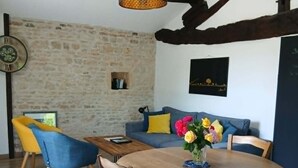 Een eethoek met een houten tafel, stoelen en een hanglamp.