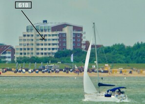A sailboat on water with a building labeled '618' in the background.