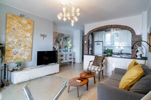 A modern living room with a flat-screen TV, a sofa, and a coffee table. - Oasis de Capistrano Rabat 27 by Casasol (Nerja)