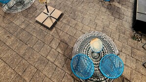 A rooftop terrace with outdoor seating, including tables and chairs, and a patterned floor. - Arthotel ANA Style (Augsburg)