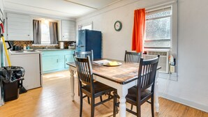 Una cocina compacta con una mesa de comedor, sillas y un refrigerador.