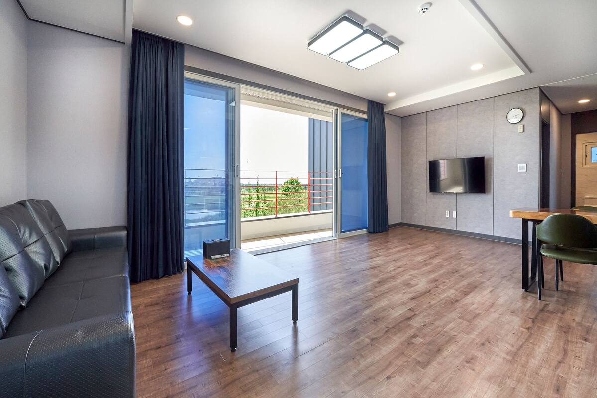 Una sala de estar moderna con un sofá, una mesa de centro y un televisor en la pared.