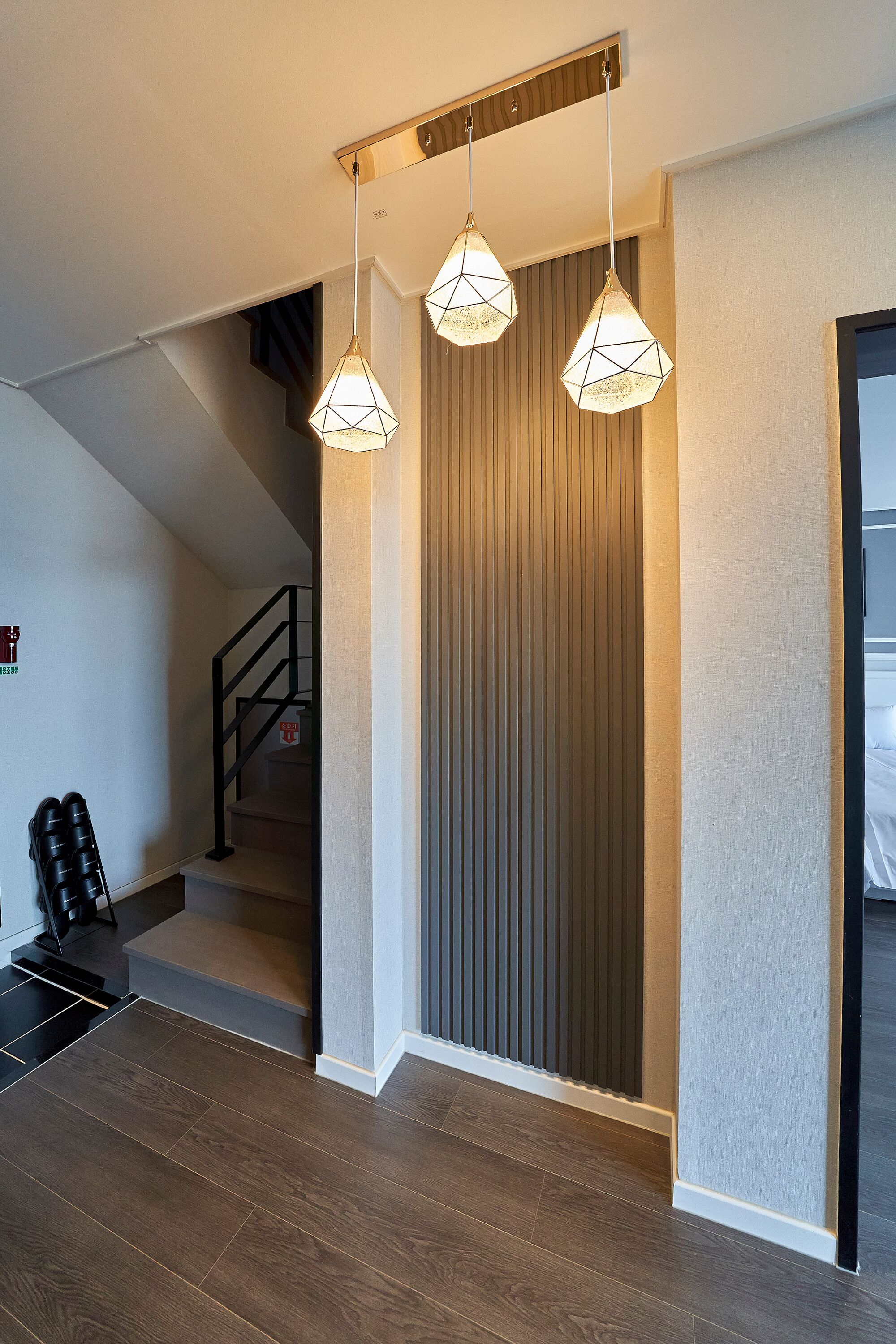 Ein modernes Interieur mit Treppe, Holzboden und Pendelleuchten.