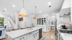 A spacious kitchen with white cabinetry, a large island, and pendant lighting. - 30A ☀️ 6 Seat Golf Cart | *Heated & Chilled Pool | Gated | Beach Equip ☀️Near Restaurants (Santa Rosa Beach)