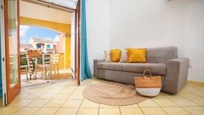 Un salon avec un canapé, un tapis tissé et un panier en osier.