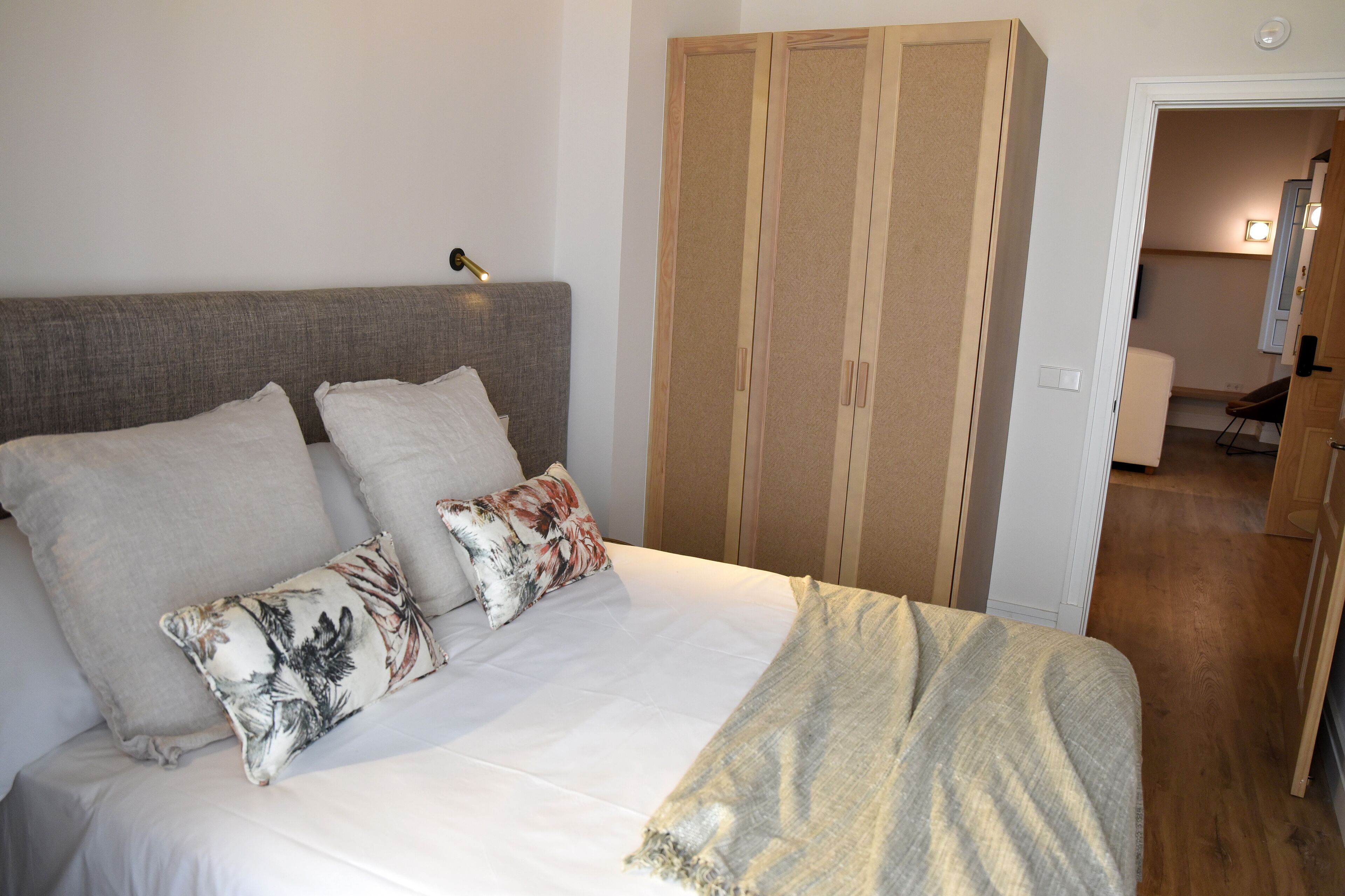 Ein Schlafzimmer mit Bett, Kissen, einer Nachttischlampe und einem Kleiderschrank.