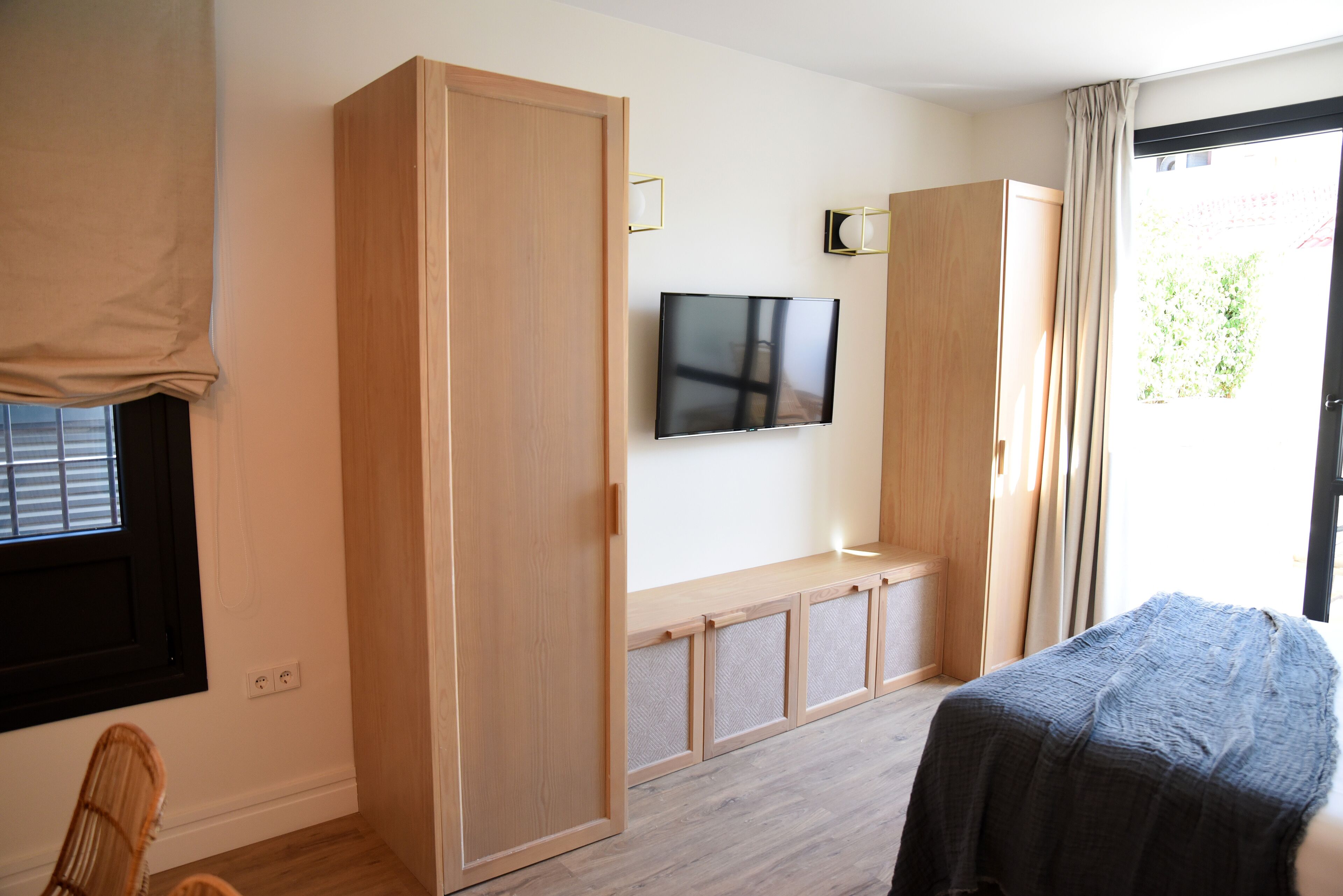 Una habitación con cama, televisor y armario.