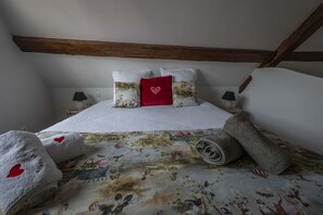 A bedroom with a bed, pillows, a blanket, and a headboard.