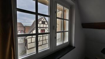 A room with a large window overlooking a traditional half-timbered house.