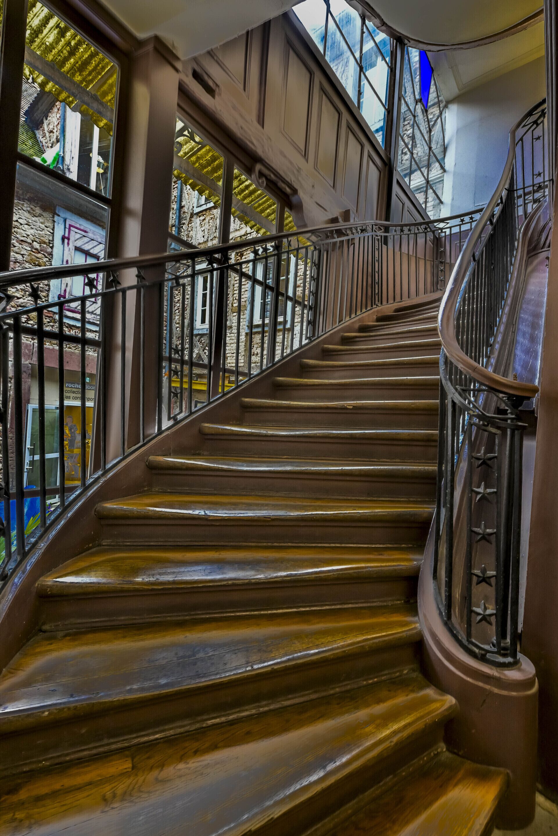 A spiral staircase with a metal railing, leading to an upper floor.