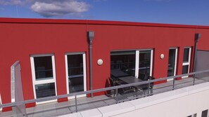 A red building with large windows and a balcony with glass railings. - BOW-1.25, sleeps 6, 70–80 m² - Bollwark 1.2 Residence (Kappeln)
