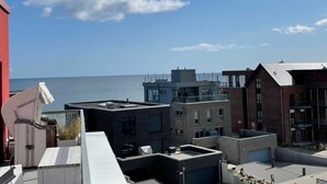 A rooftop terrace with a view of the sea, featuring modern buildings with flat roofs and a mix of brick and concrete construction. - BOW-1.25, 6 pers., 70-80sqm - Residence Bollwark 1.2 (Kappeln)