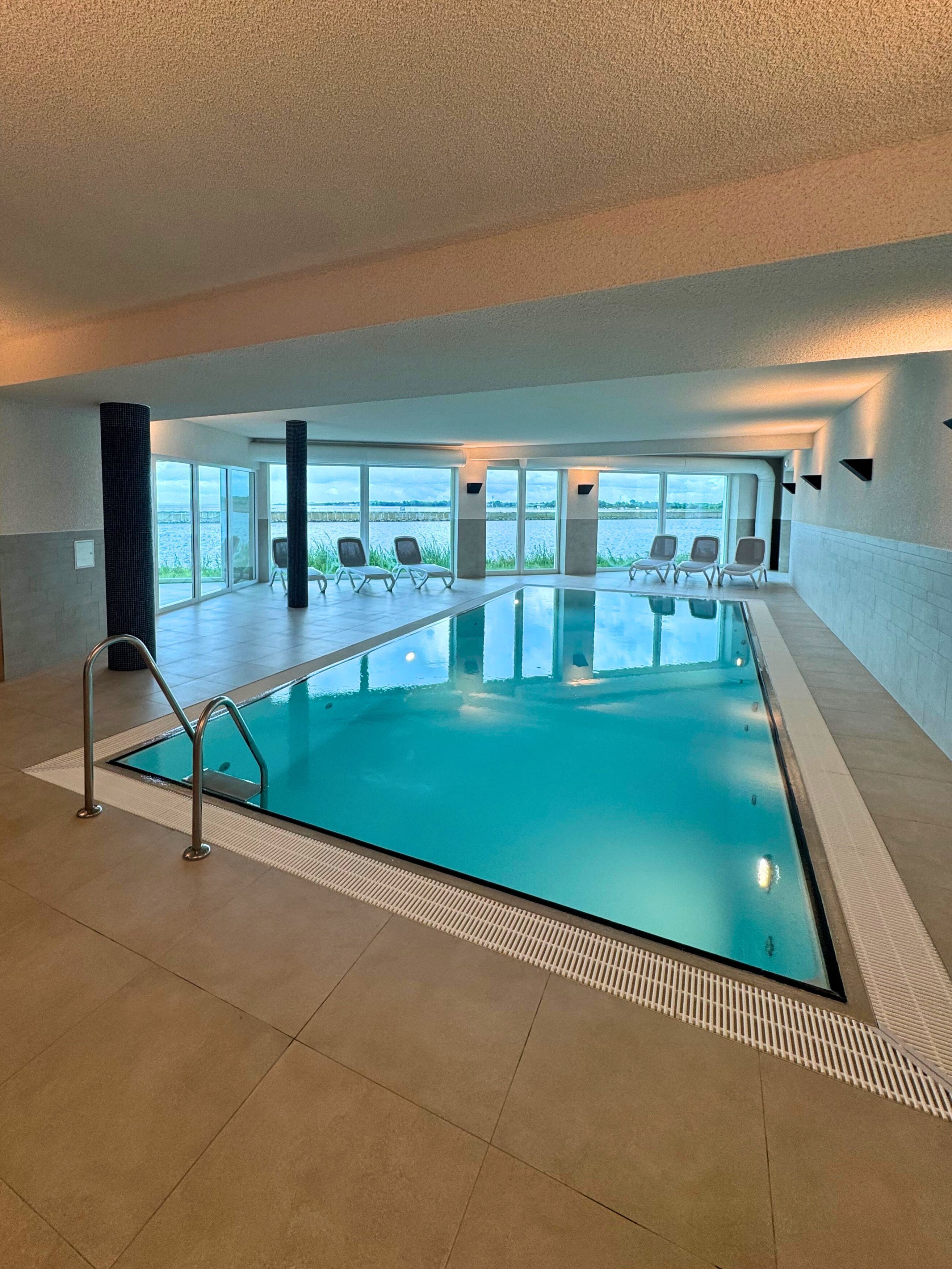 Une piscine intérieure offrant une vue dégagée sur l’extérieur.