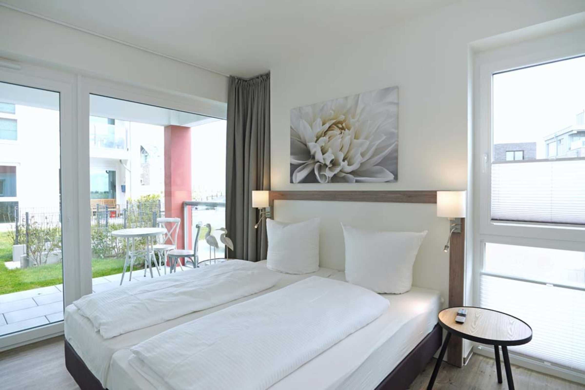 Een hotelkamer met een groot bed, een tafeltje en uitzicht op het buitengebied.