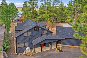 A two-story house with a sloped roof, a covered porch, and a garage. - Rustic Lakefront! PET FRIENDLY! Boat Dock! Pool Table! HOT TUB! (Big Bear Lake)