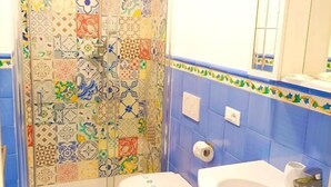A bathroom with a shower, two bidets, a sink, and a mirror. - Agora Apartments Casetta Sorrentina (Sorrento)