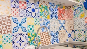A kitchen with colorful tiles, a sink, and a coffee setup. - Agora Apartments Casetta Sorrentina (Sorrento)