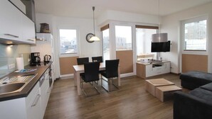 Una cocina moderna con comedor, televisor y sofá.