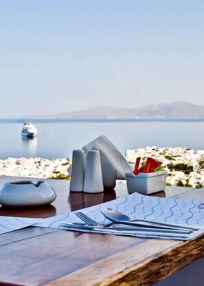 Enjoy a serene meal with a view of the calm water and distant landmass.