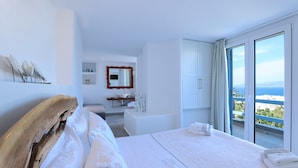 A modern bedroom with a large bed, a bathroom with a bathtub, and a balcony with a view of the sea. - Ibiscus Boutique Hotel (Mykonos)