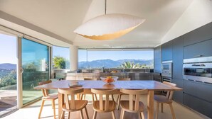 A modern kitchen with a large island, stainless steel appliances, and a view of mountains.