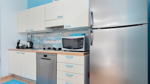 Una cocina compacta equipada con lavavajillas, microondas y refrigerador de acero inoxidable.