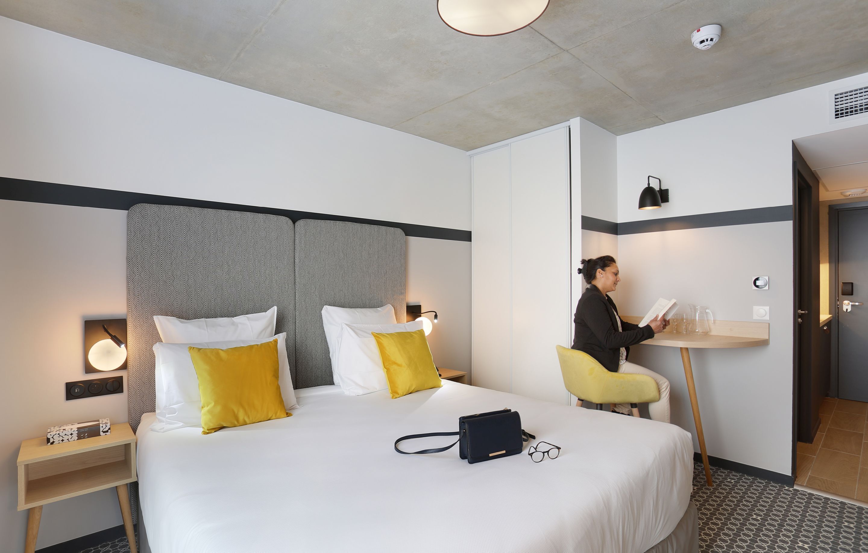 Une chambre d’hôtel avec un grand lit, des tables de chevet, un bureau et une chaise.