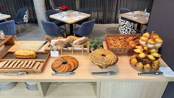 A bakery display with various breads and pastries, including a sign for 'Odalys Pancake beurre'.