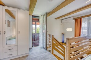 A modern interior with a wooden staircase, a white wardrobe, and a view to the outside. - Merry's House w/ Pool & Sauna (Črnomelj)