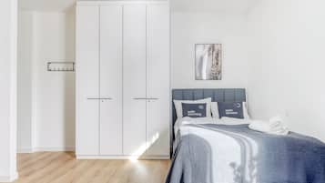A bedroom with a bed, a wardrobe, and a painting on the wall.