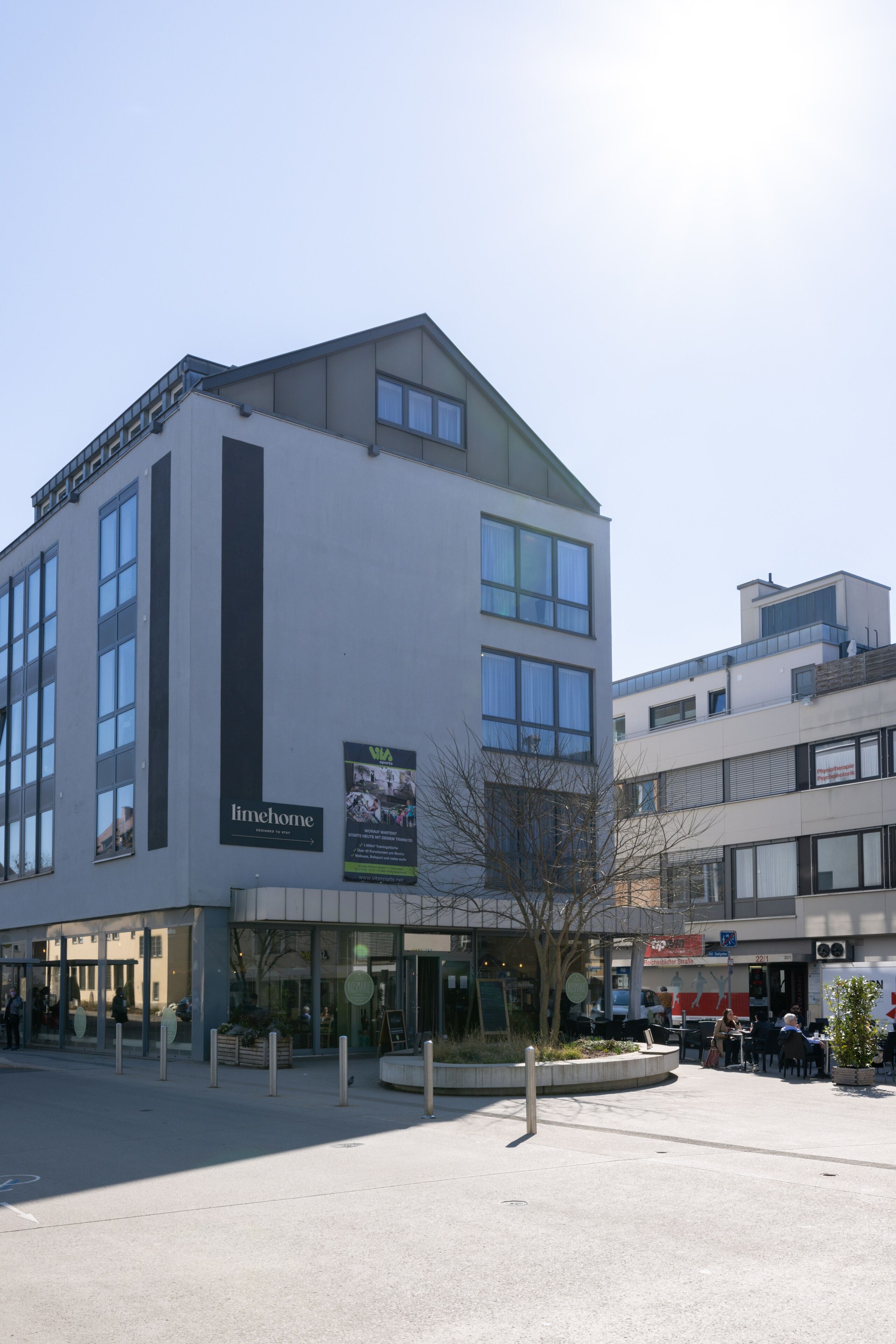 Un edificio moderno con fachada de vidrio y un cartel que dice 'limehome'.