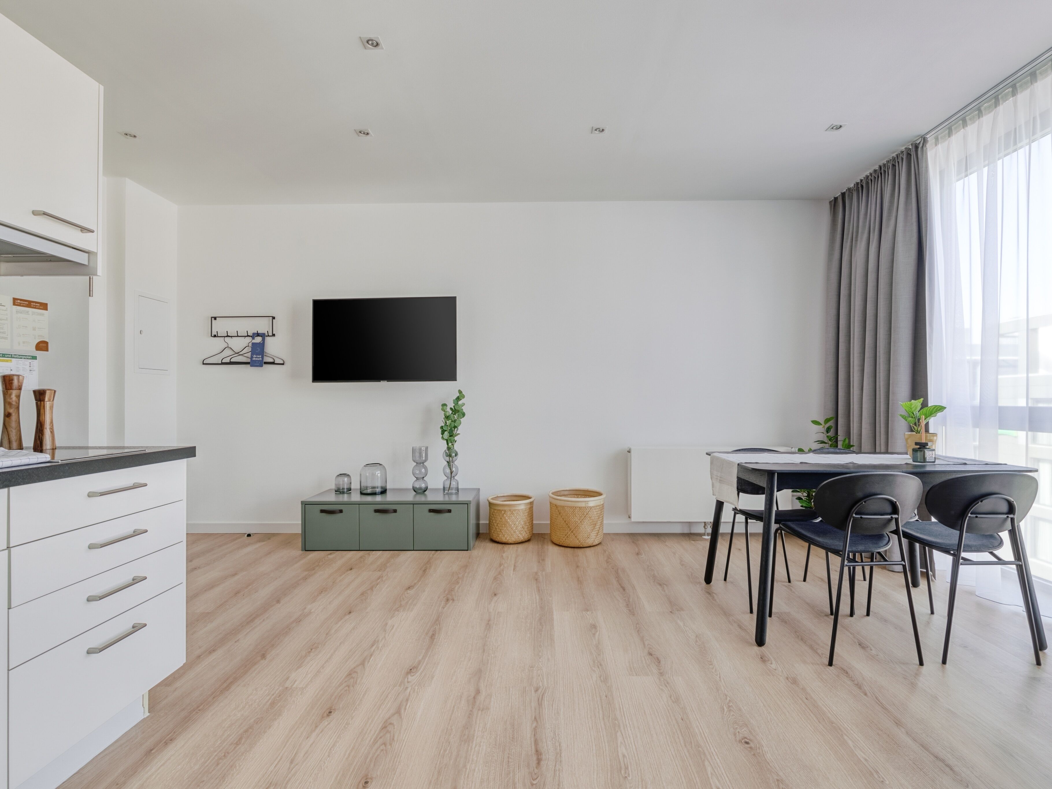 A modern kitchen with white cabinets, a black countertop, and a built-in oven.