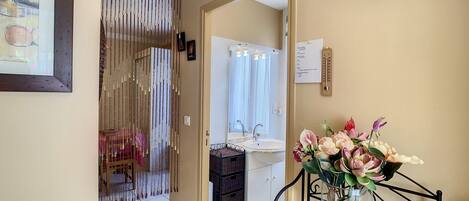 Une salle de bain avec un lavabo, un miroir et une horloge au mur.
