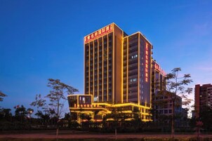 A multi-story hotel building with illuminated signage and a prominent entrance.
