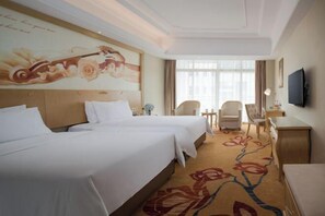 A hotel room with two beds, a desk, a chair, a TV, and a large window. - Vienna International Hotel (Danzhou Yangpu) (Danzhou)