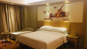 Habitación de hotel con una cama grande, una mesita de noche, una silla, una pequeña mesa redonda y un mural en la pared con una guitarra y libros.