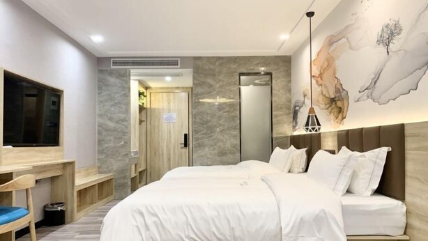 A modern hotel room with a large bed, a desk, and a seating area. - Qingmu Select Hotel (Jintan No.4 Middle School Yaoban Branch) (Changzhou)