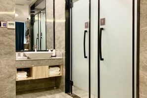 Une salle de bain moderne avec un lavabo en marbre, des porte-serviettes et un miroir.