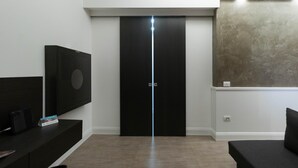 A modern hotel room with a black wardrobe, a flat-screen TV mounted on the wall, and a 'No Smoking' sign on the counter. - Italianway Collection - Corso Venezia 7 - Tosca (Milan)