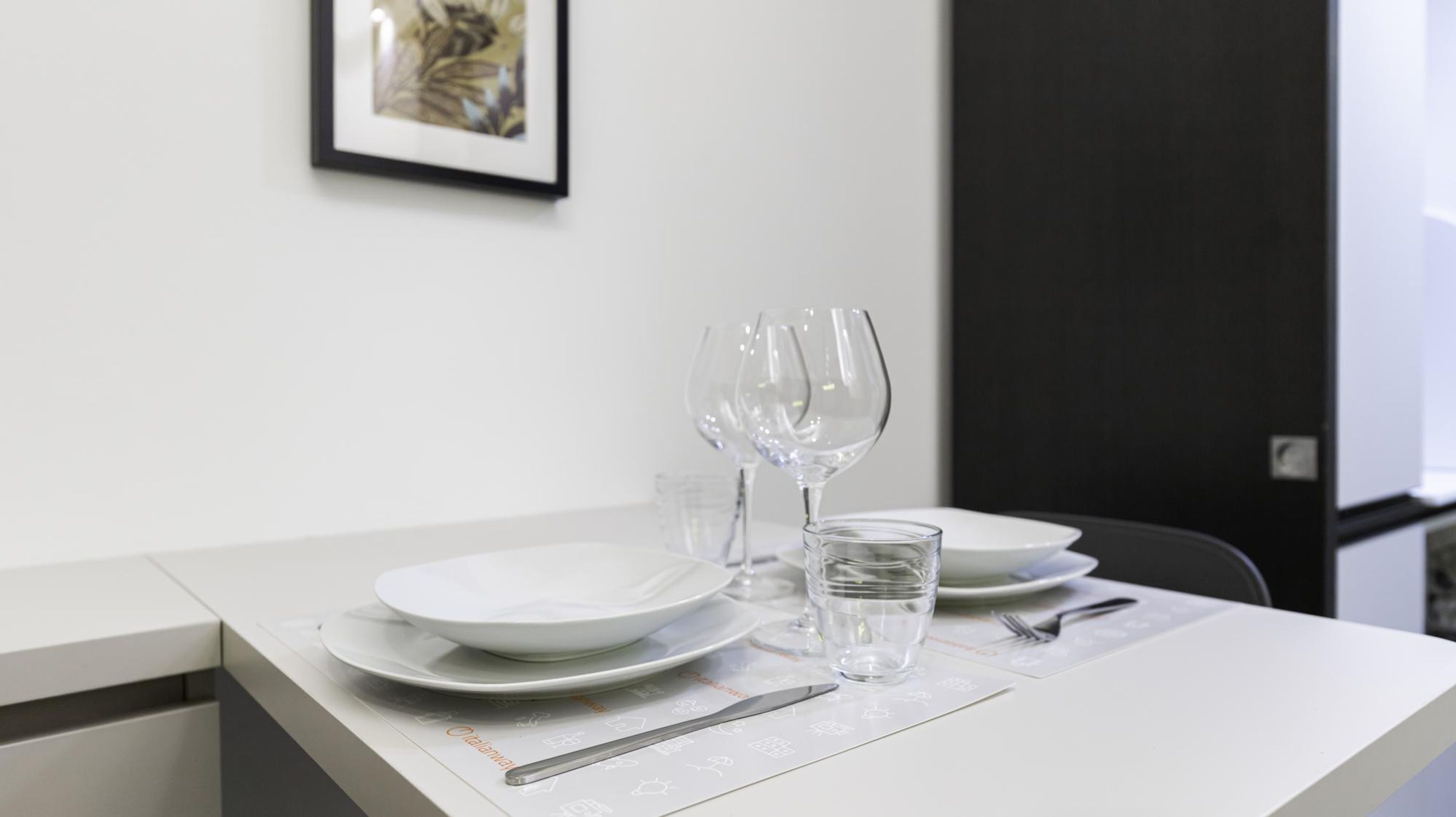 Une table à manger élégamment dressée, avec des assiettes, des verres et des couverts.