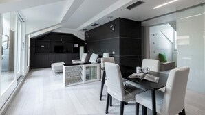 A modern dining area with a glass partition, white chairs, and a black table. - Italianway Collection - Corso Venezia 7 - Traviata (Milan)