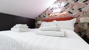 A neatly made bed with folded towels, a red headboard, and a wall with a 'FINA WAY' neon sign. - Italianway Collection - Corso Venezia 7 - Traviata (Milan)